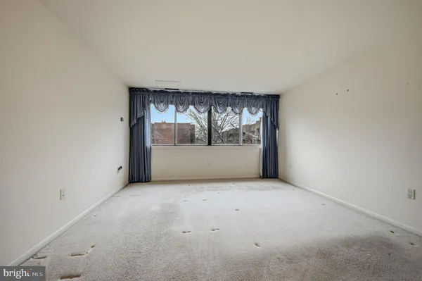 an empty room with a fireplace and wooden floor