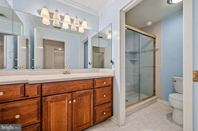 a bathroom with a granite countertop sink a toilet and shower