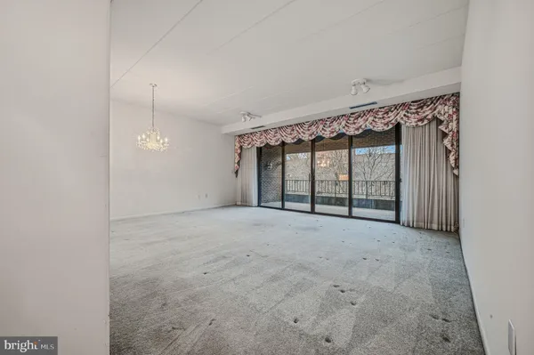 an empty room with windows and ceiling fan