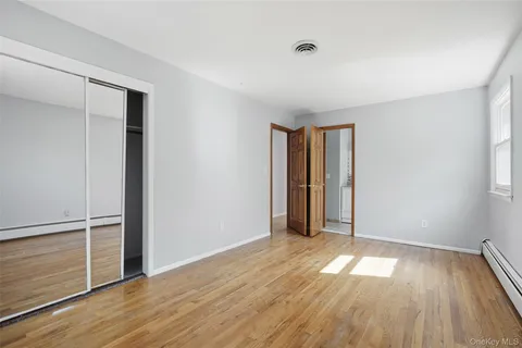 an empty room with wooden floor and a window