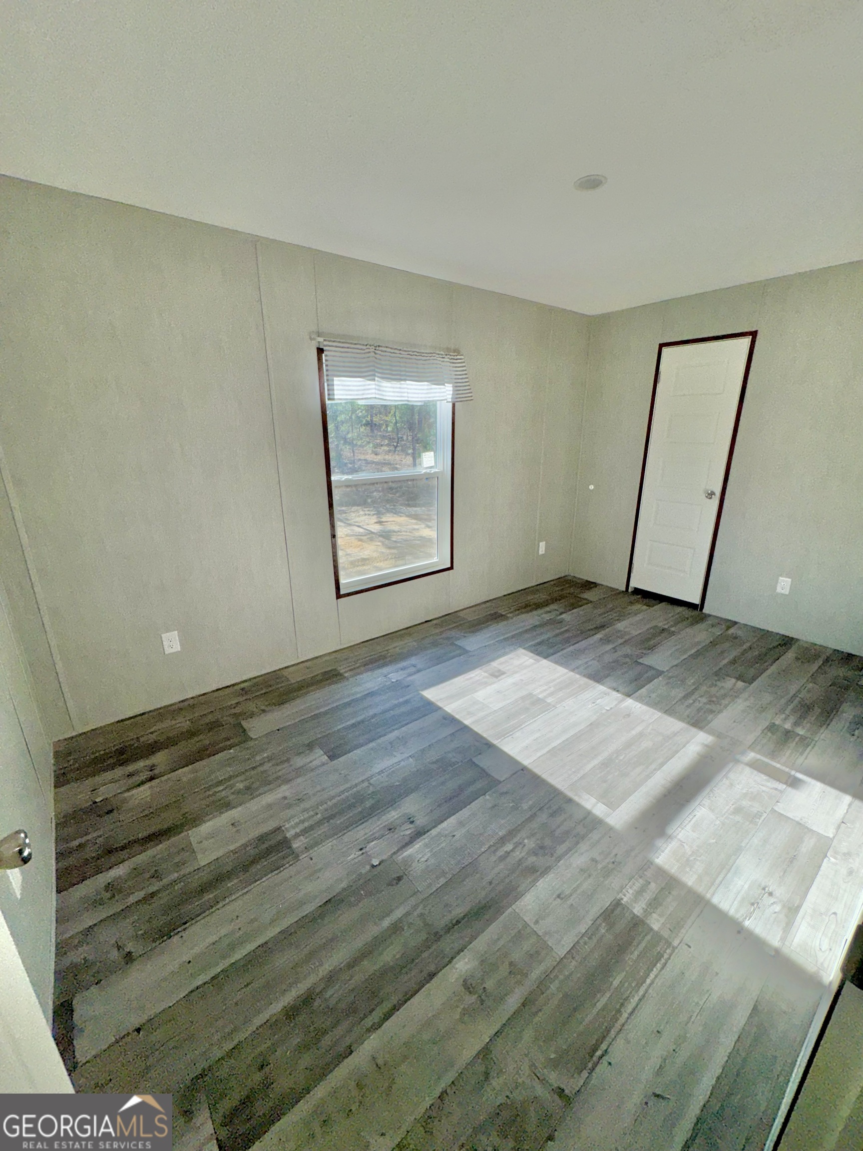 545 Ben Jackson Road Vidalia, GA 30474 - Photo 18 of 25 a view of an empty room with wooden floor and a window
