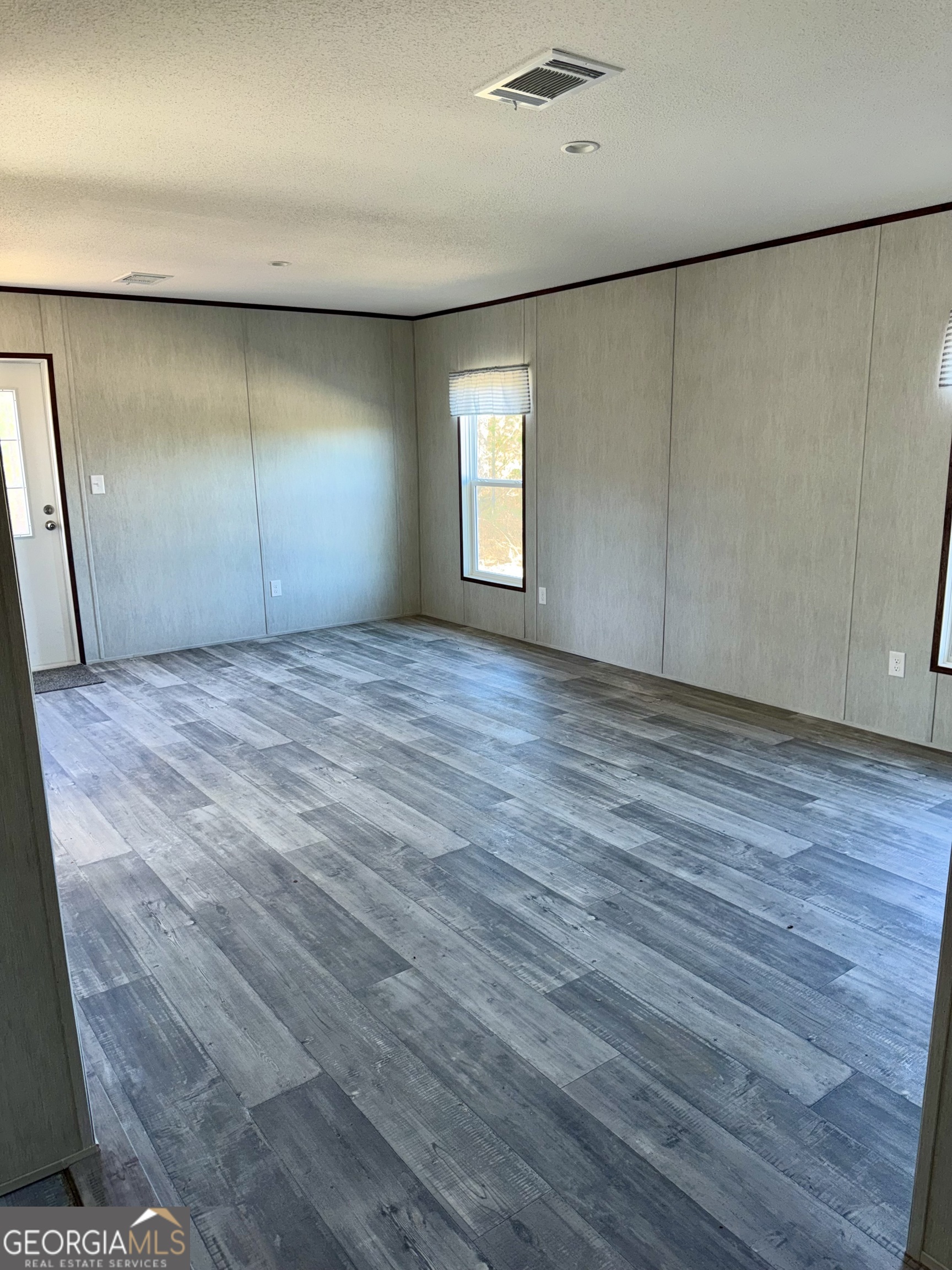 545 Ben Jackson Road Vidalia, GA 30474 - Photo 20 of 25 a view of an empty room with wooden floor and a window