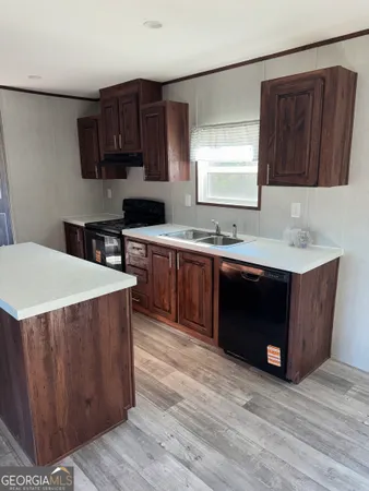 a kitchen with stainless steel appliances a sink a stove a refrigerator and cabinets