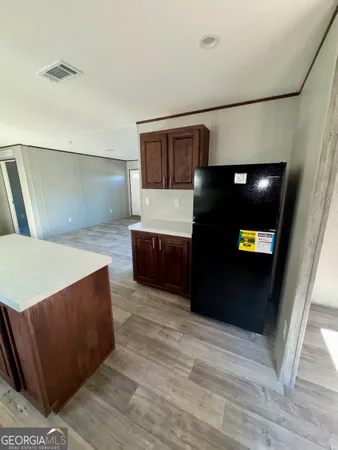 a living room with stainless steel appliances kitchen island granite countertop furniture and a refrigerator