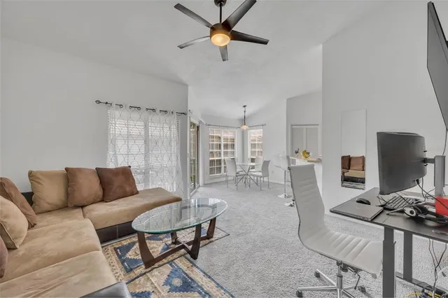 a living room with furniture a ceiling fan and a rug