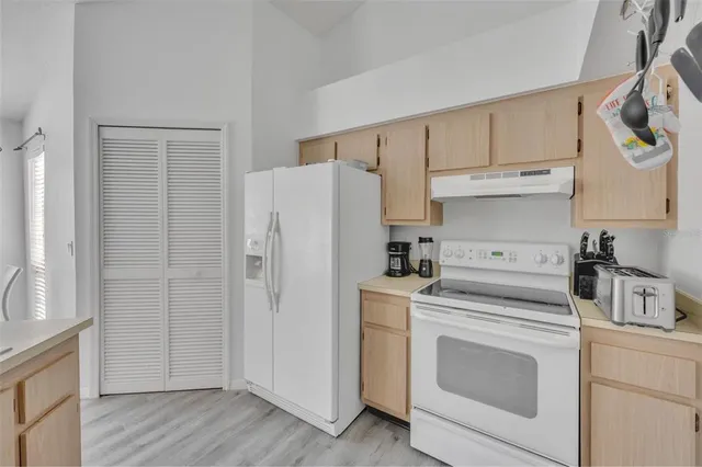 a view of a kitchen with refrigerator and cabinets