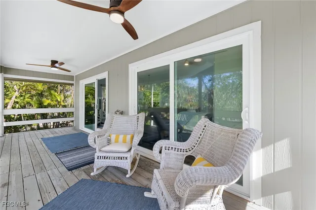 a dining room with furniture a rug a flat screen tv and a large window