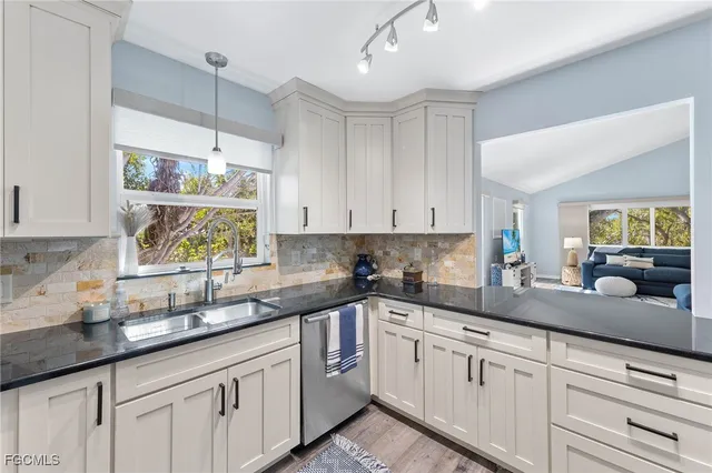 a kitchen with kitchen island granite countertop white cabinets and white appliances