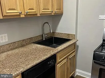 a close view of a sink a counter space and a stove in a kitchen