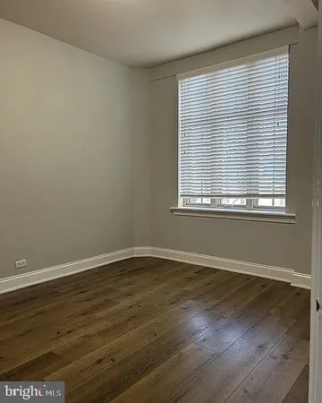 an empty room with wooden floor and a window