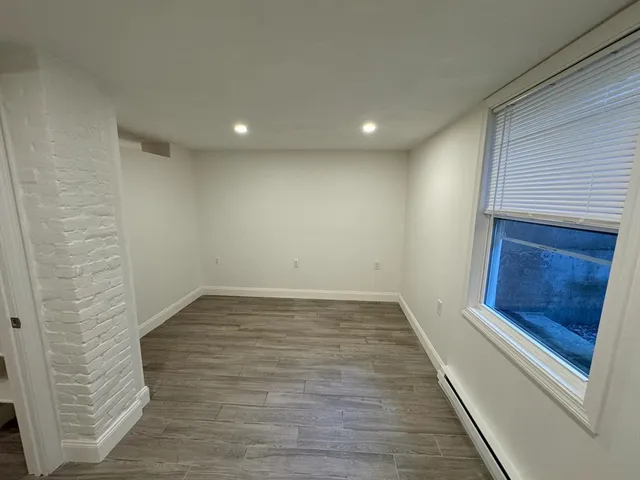 a view of empty room with wooden floor and fireplace
