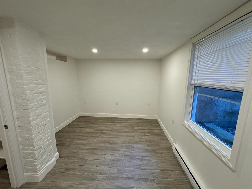 27 Salem Street, Unit 4 Woburn, MA 01801 - Photo 3 of 7 a view of empty room with wooden floor and fireplace