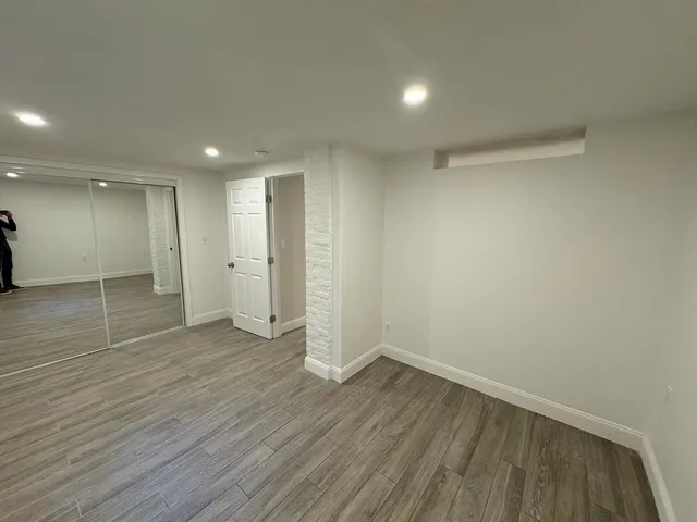 a view of empty room with wooden floor