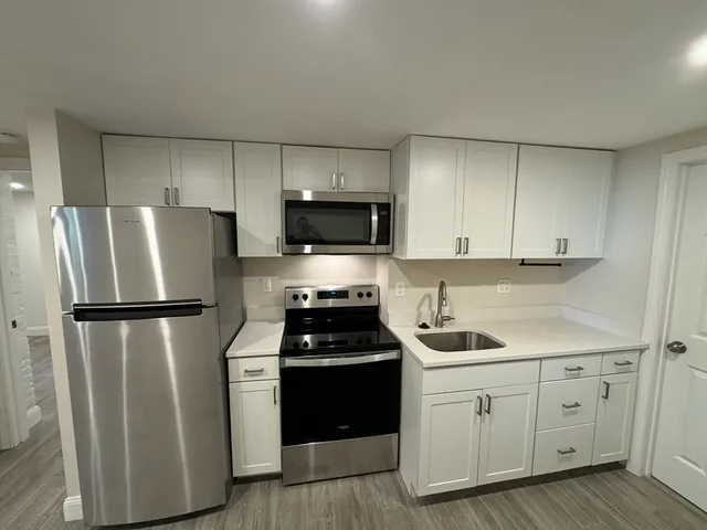 a kitchen with a refrigerator sink and cabinets