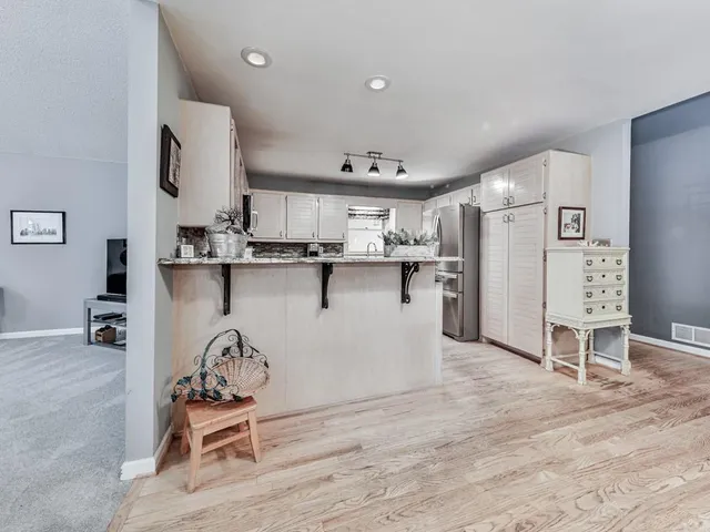 a kitchen with stainless steel appliances a refrigerator and wooden floor