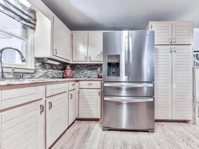 a kitchen with stainless steel appliances kitchen island wooden cabinets and a refrigerator