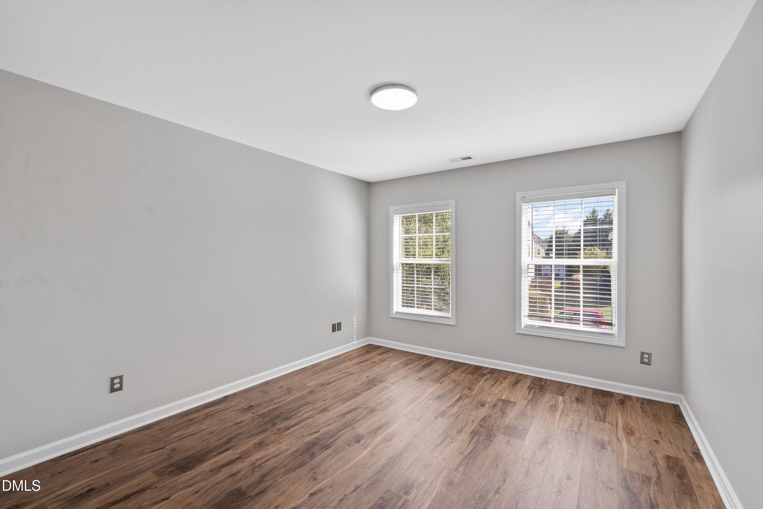 3717 Windmeade Road Wake Forest, NC 27587 - Photo 41 of 51 an empty room with wooden floor and windows