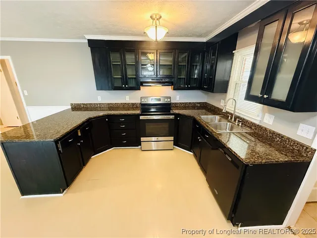 a kitchen with granite countertop a sink stove and cabinets