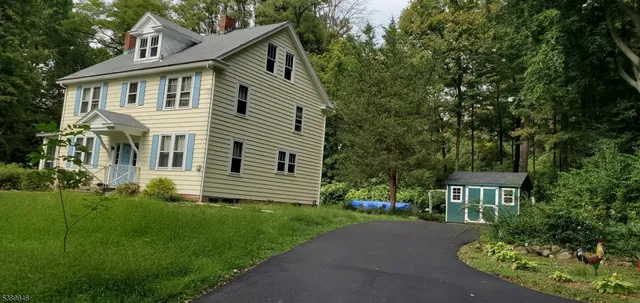 a front view of a house with a yard and trees