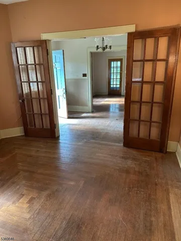 a view of a hallway with wooden floor and windows