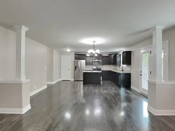 a large open kitchen with a refrigerator a sink dishwasher with a dining table and chairs