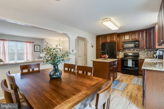 a living room with furniture kitchen view and a large window