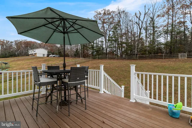 a view of deck with dinning table and chair under an umbrella