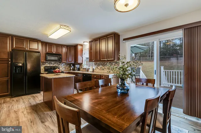 a kitchen with a table chairs refrigerator and cabinets
