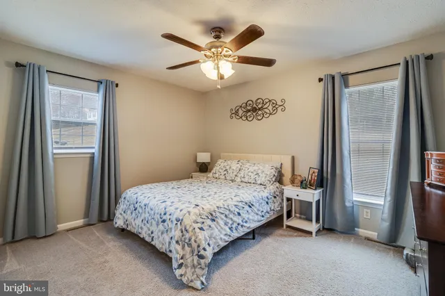 a bedroom with a bed and a large mirror with a dresser