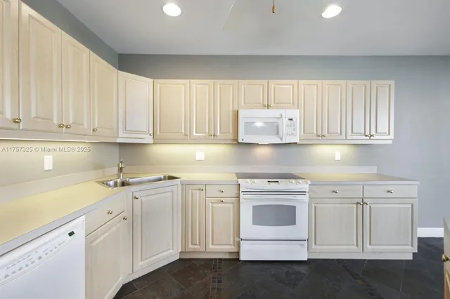 a kitchen with white cabinets and white appliances