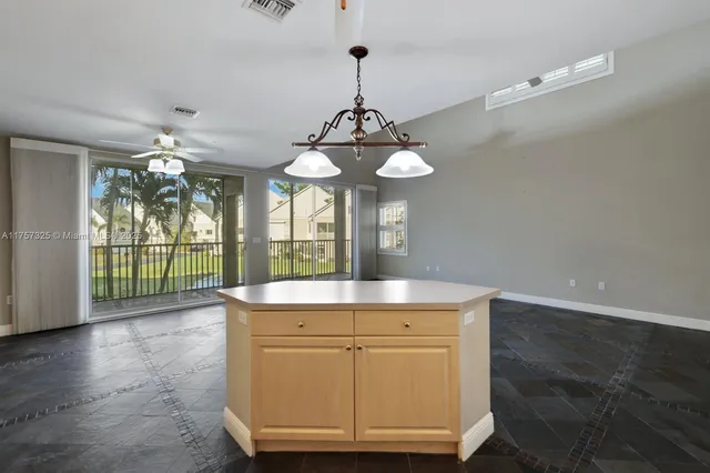 a view of a kitchen with granite countertop a sink and dishwasher with wooden floor