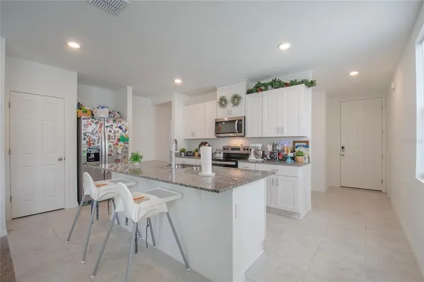 a kitchen with white cabinets and refrigerator