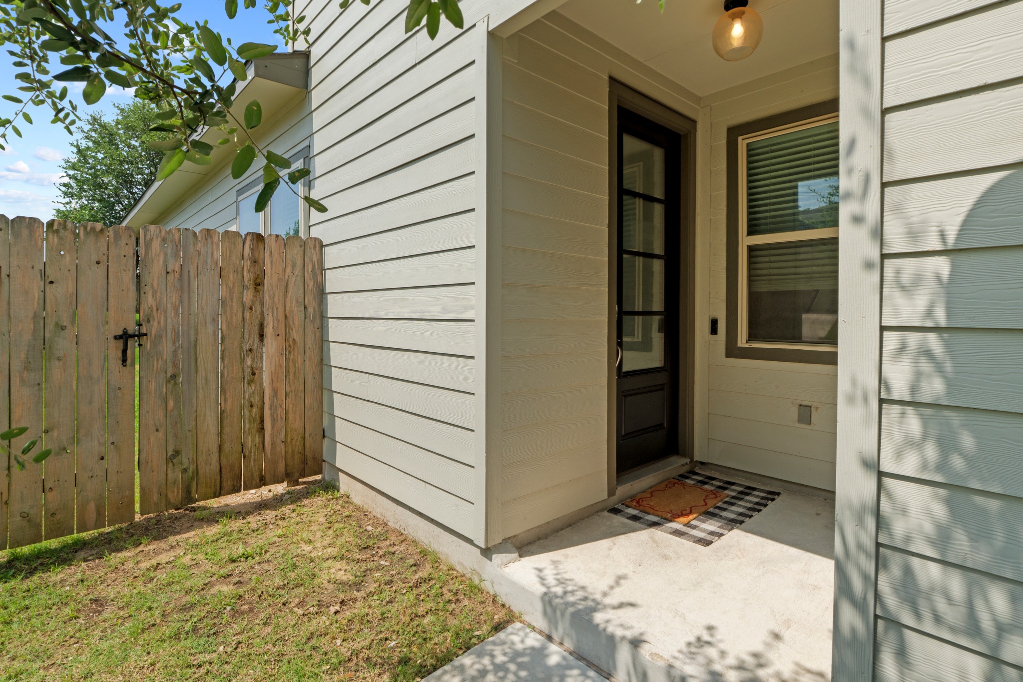 1101 Skeeter Cove Austin, TX 78748 - Photo 4 of 31 A welcoming front entrance features sturdy siding and a wooden fence, ensuring both privacy and visual appeal.