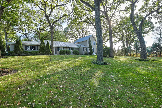 a view of a house with a yard and tree