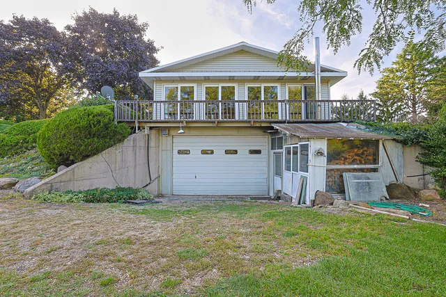 a front view of a house with a yard and trees