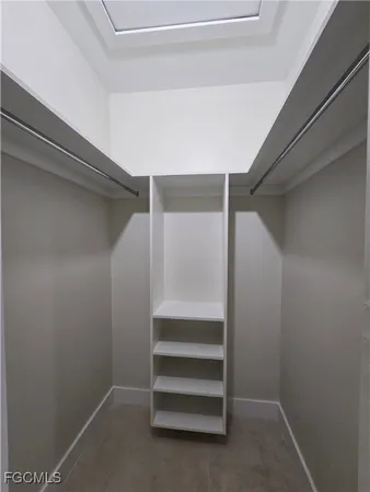 a view of walk in closet with empty racks