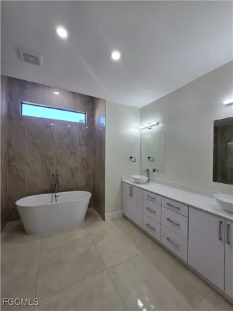 a bathroom with a double vanity sink toilet and bathtub