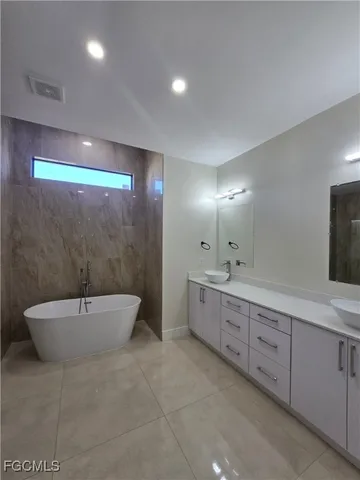 a bathroom with a double vanity sink toilet and bathtub