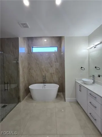 a spacious bathroom with a bathtub sink mirror and toilet