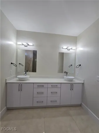 a bathroom with a double vanity sink and a mirror