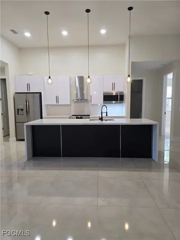 a large kitchen with kitchen island a sink stainless steel appliances and cabinets