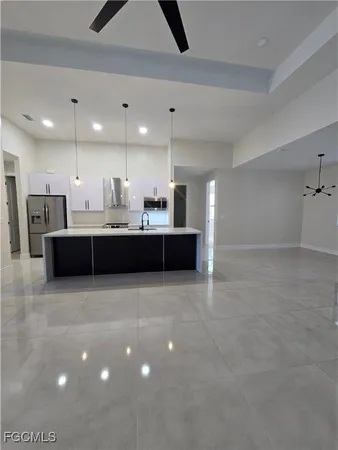 a kitchen with kitchen island a sink stainless steel appliances and a counter top space