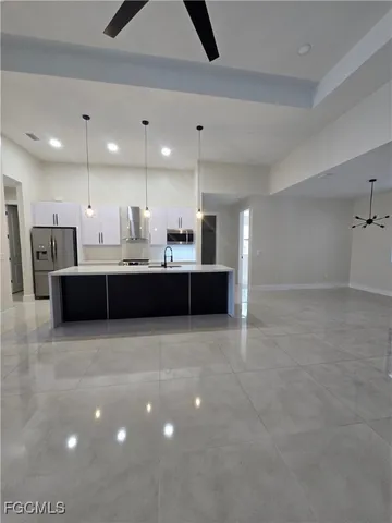 a kitchen with kitchen island a sink stainless steel appliances and a counter top space