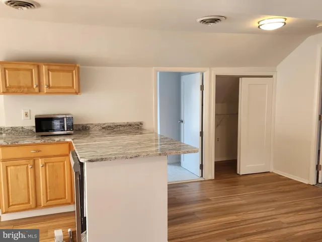 a kitchen with granite countertop cabinets and wooden floor
