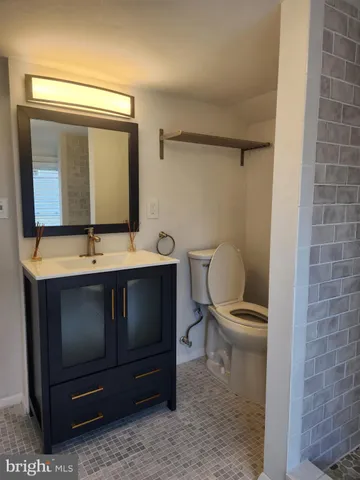 a bathroom with a toilet a sink and mirror