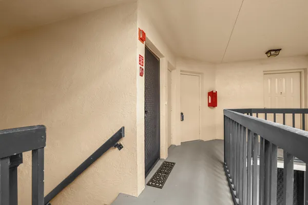 a view of a hallway to a livingroom with wooden floor and stairs