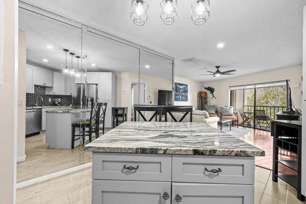 a counter top space a stove and a chandelier