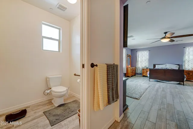 a spacious bathroom with a toilet a sink and a mirror