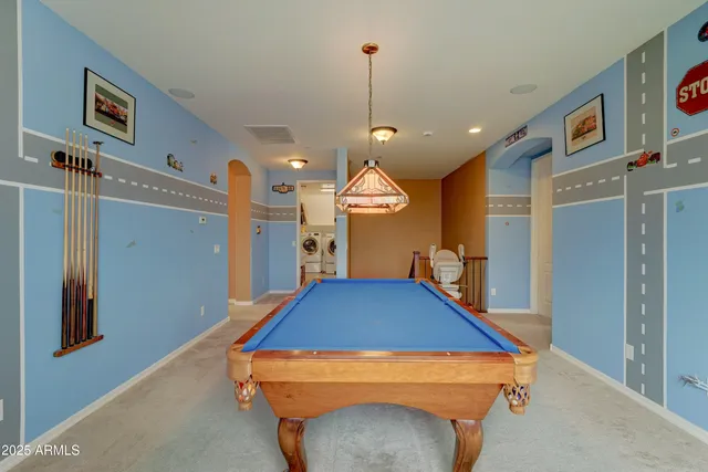 a room with pool table and a chandelier