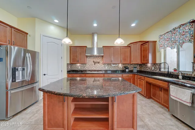 a kitchen with stainless steel appliances granite countertop a sink a stove and a refrigerator
